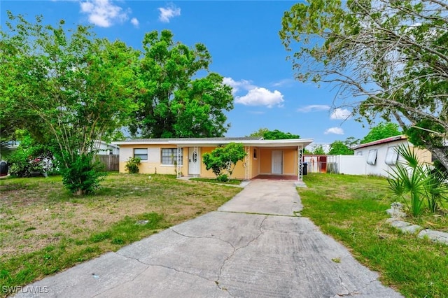 single story home with a front lawn, fence, driveway, and a carport