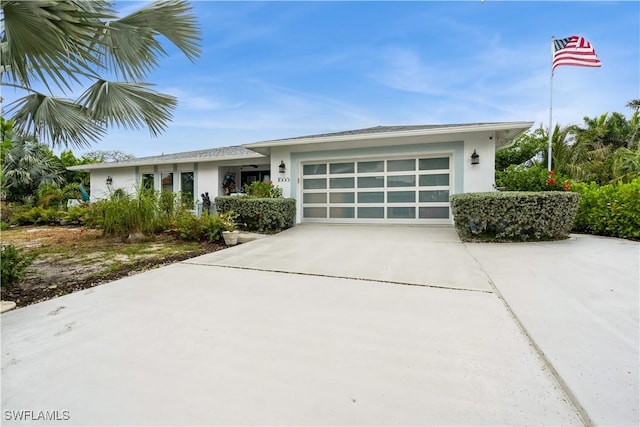view of front of property with stucco siding, concrete driveway, and a garage