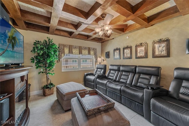 home theater featuring coffered ceiling, ceiling fan, light tile patterned floors, and a glass covered fireplace