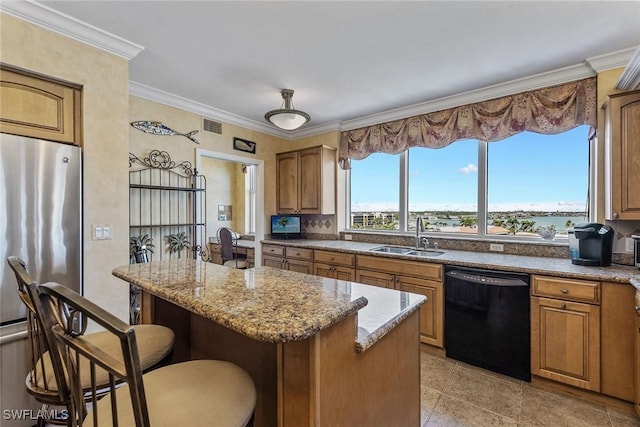 kitchen with freestanding refrigerator, a kitchen bar, a center island, a sink, and dishwasher