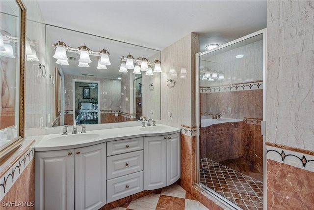 ensuite bathroom featuring double vanity, a shower stall, a sink, and ensuite bath