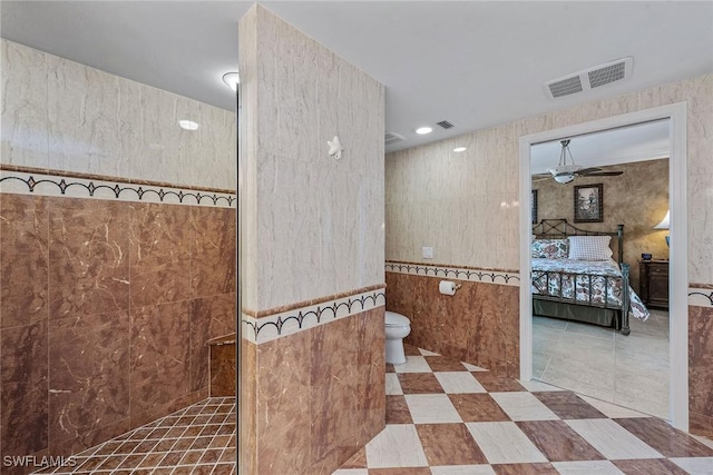 bathroom featuring visible vents, toilet, a walk in shower, a ceiling fan, and ensuite bath
