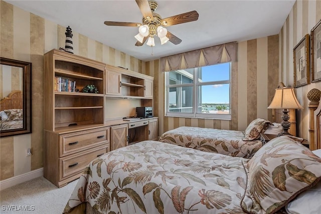 bedroom featuring baseboards, a ceiling fan, light carpet, and wallpapered walls