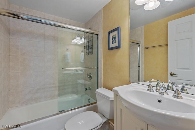 full bathroom featuring vanity, enclosed tub / shower combo, and toilet