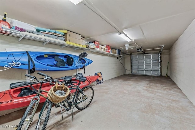 garage featuring concrete block wall and a garage door opener