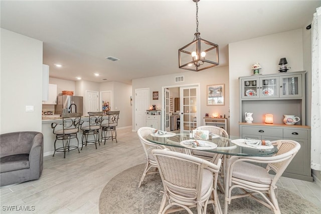 dining area with french doors, visible vents, baseboards, a chandelier, and light wood-style floors
