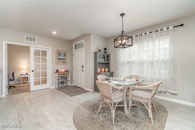 dining area featuring a chandelier, french doors, baseboards, light wood-type flooring, and visible vents