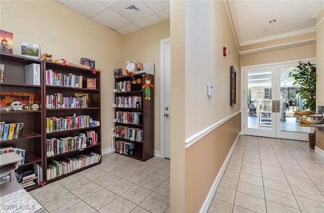 hall featuring french doors, visible vents, light tile patterned floors, baseboards, and ornamental molding