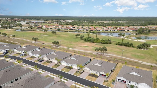 drone / aerial view featuring a water view, view of golf course, and a residential view