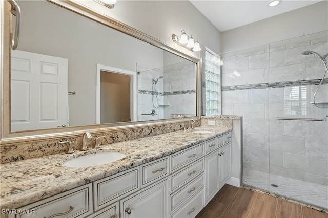 10419 Materita Dr, Fort Myers, FL 33913 - full bathroom with tiled shower, double vanity, and wood finished floors