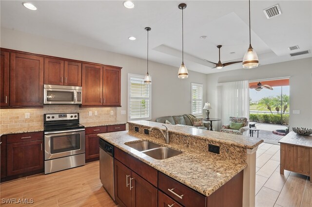 10419 Materita Dr, Fort Myers, FL 33913 - kitchen featuring stainless steel appliances, open floor plan, decorative backsplash, ceiling fan, and pendant lighting