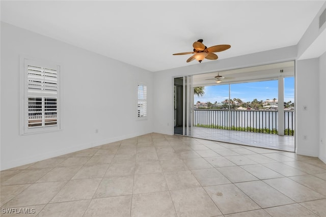 9380 Gulf Shore Dr Unit 101, Naples, FL 34108 - empty room with a ceiling fan, a water view, and light tile patterned flooring