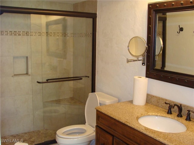 4070 Looking Glass Ln Unit 3101, Naples, FL 34112 - bathroom featuring vanity, toilet, a textured wall, and a shower stall
