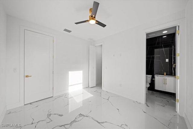 unfurnished bedroom featuring visible vents, marble finish floor, baseboards, ceiling fan, and ensuite bath