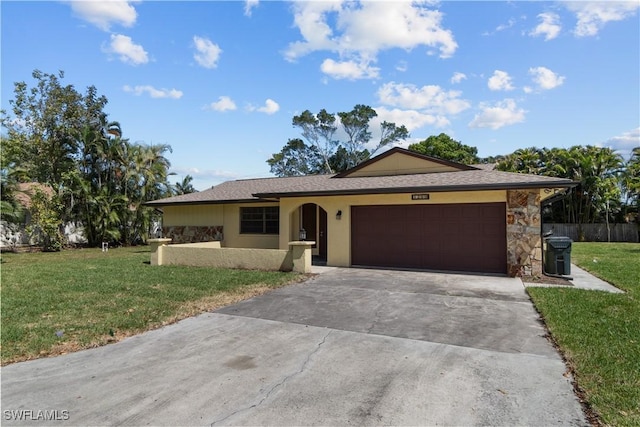 ranch-style home with stone siding, a garage, stucco siding, a front yard, and driveway