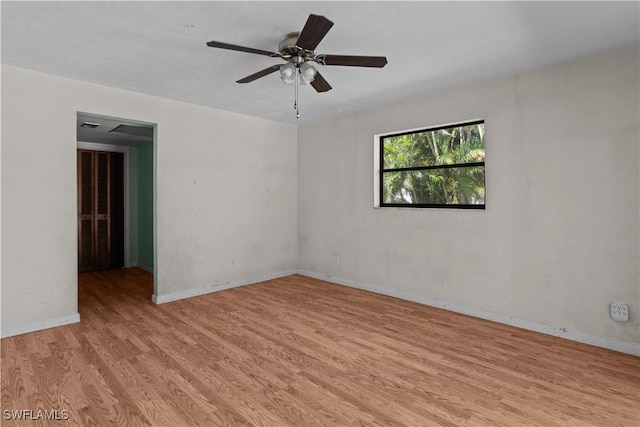 empty room featuring baseboards, ceiling fan, and light wood-style flooring