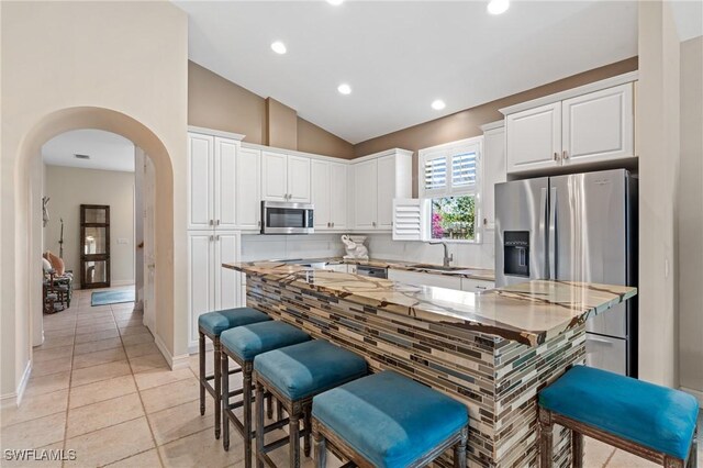 636 102nd Ave N, Naples, FL 34108 - kitchen with appliances with stainless steel finishes, a sink, arched walkways, white cabinets, and recessed lighting