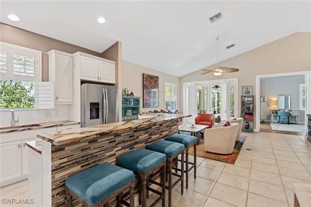 636 102nd Ave N, Naples, FL 34108 - kitchen featuring stainless steel fridge with ice dispenser, a sink, light tile patterned flooring, open floor plan, and white cabinets