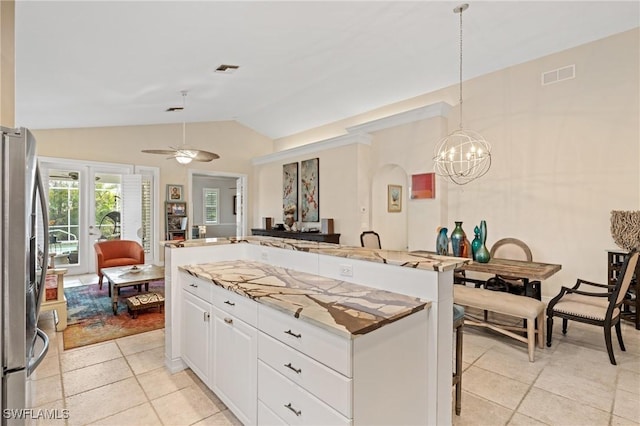 636 102nd Ave N, Naples, FL 34108 - kitchen with freestanding refrigerator, open floor plan, light tile patterned floors, lofted ceiling, and a center island