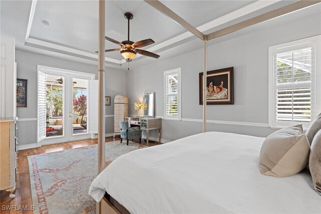 636 102nd Ave N, Naples, FL 34108 - bedroom featuring a raised ceiling, multiple windows, access to exterior, and wood finished floors