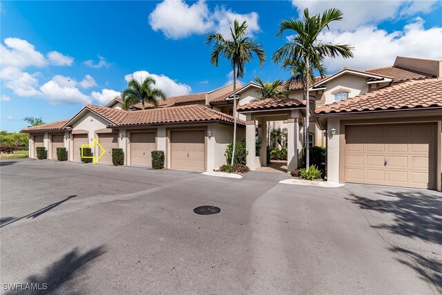 162 Newport Dr Unit 1208, Naples, FL 34114 - mediterranean / spanish house with stucco siding, a tile roof, and community garages