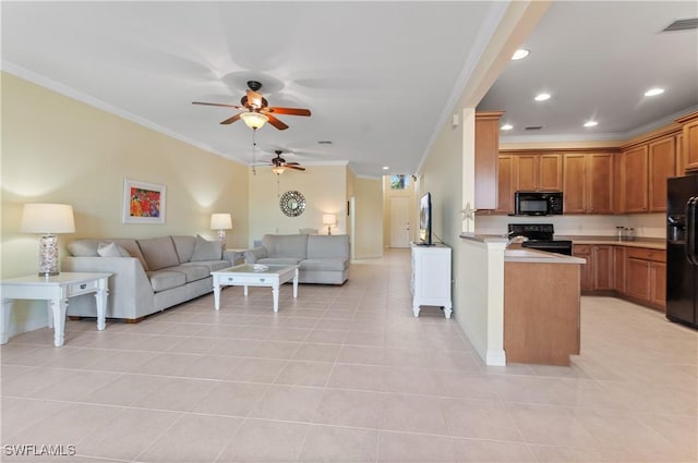 kitchen with light countertops, a ceiling fan, open floor plan, ornamental molding, and black appliances