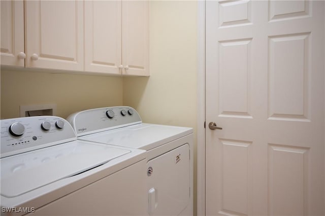 laundry room featuring washing machine and clothes dryer and cabinet space