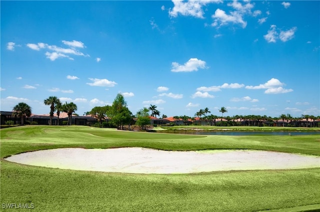 view of property's community featuring a lawn, a water view, and view of golf course