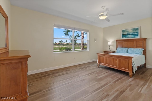 bedroom featuring a ceiling fan, baseboards, and light wood finished floors
