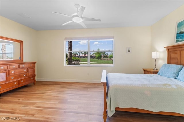 bedroom featuring baseboards, ceiling fan, and light wood-style floors