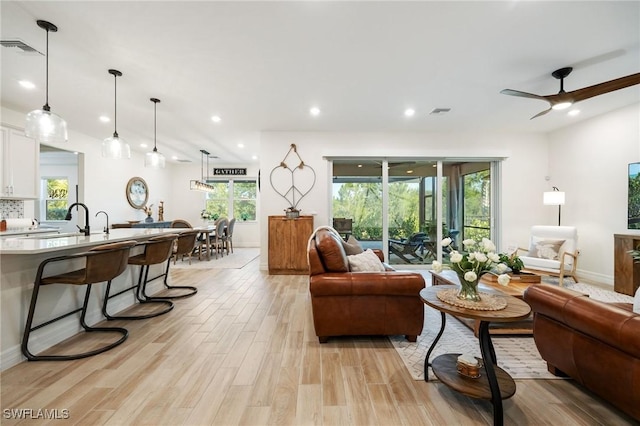 living area with visible vents, a ceiling fan, light wood-style floors, and recessed lighting
