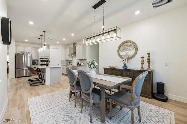 dining space with visible vents, recessed lighting, light wood-style floors, and baseboards