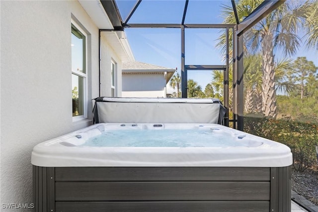 exterior space with a hot tub and a lanai