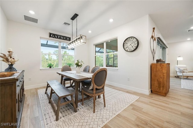 dining area featuring baseboards, visible vents, and light wood finished floors
