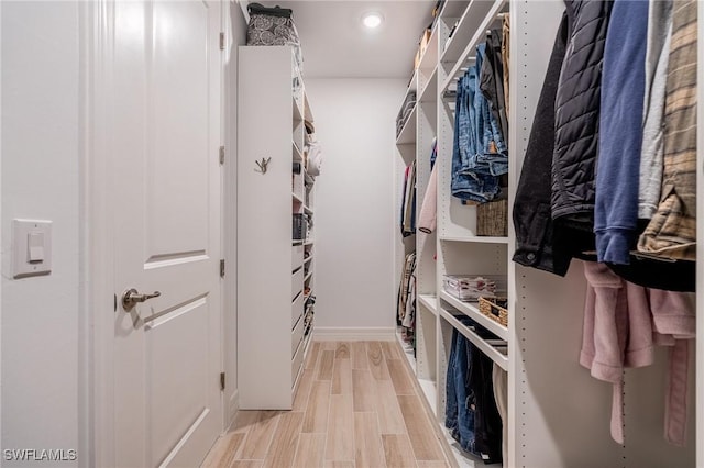 walk in closet with light wood-type flooring