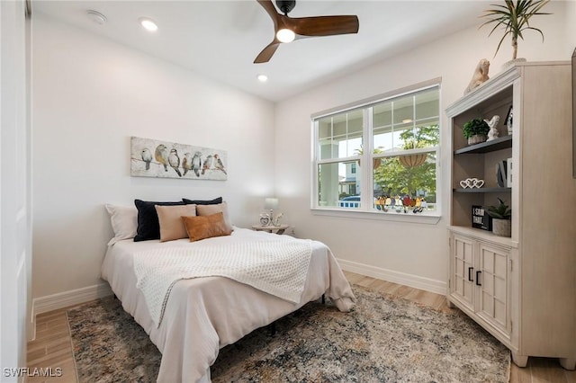bedroom with baseboards, a ceiling fan, and light wood finished floors