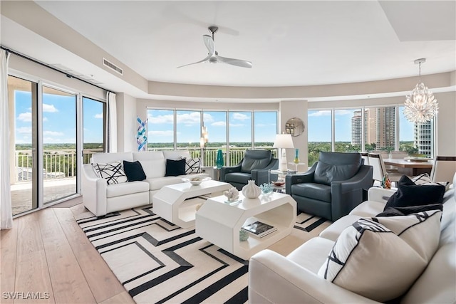 4931 Bonita Bay Blvd Unit 601, Bonita Springs, FL 34134 - living room featuring visible vents, plenty of natural light, ceiling fan with notable chandelier, and hardwood / wood-style floors