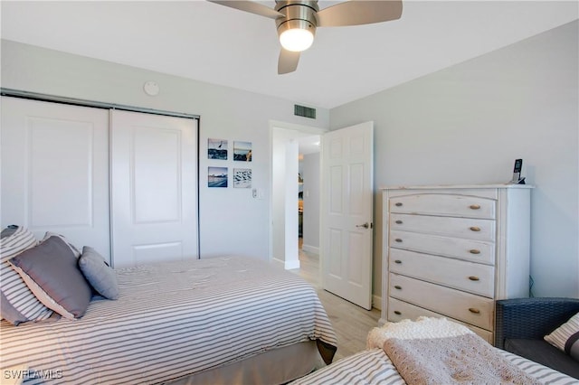 bedroom with a closet, a ceiling fan, visible vents, and light wood-style floors