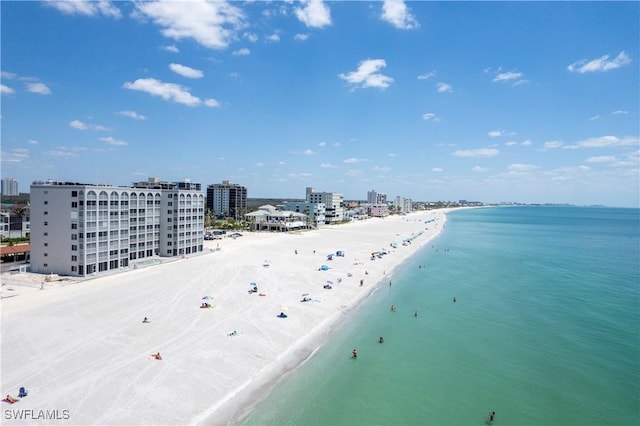 birds eye view of property featuring a water view, a view of city, and a beach view