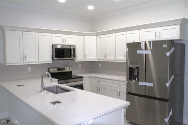 2406/2404 Hawalaska St, Lehigh Acres, FL 33973 - kitchen with appliances with stainless steel finishes, a sink, a peninsula, ornamental molding, and white cabinets