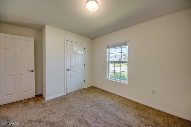 unfurnished bedroom with carpet floors and baseboards