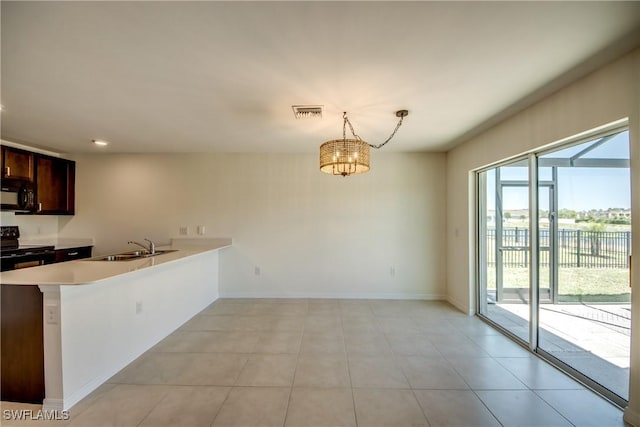 kitchen featuring visible vents, a peninsula, light countertops, a sink, and black appliances