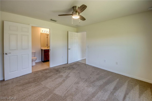 unfurnished bedroom featuring baseboards, visible vents, carpet, and ensuite bath
