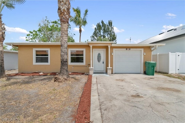 view of front of property with an attached garage, fence, driveway, and stucco siding