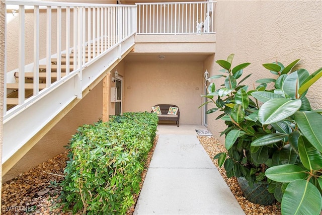 entrance to property featuring stucco siding and a balcony