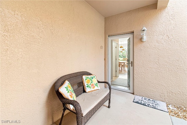 entrance to property with stucco siding and a balcony