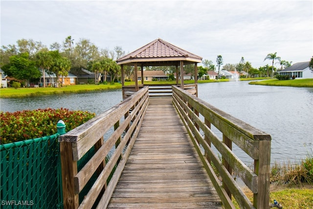 view of dock with a gazebo, a water view, and a residential view