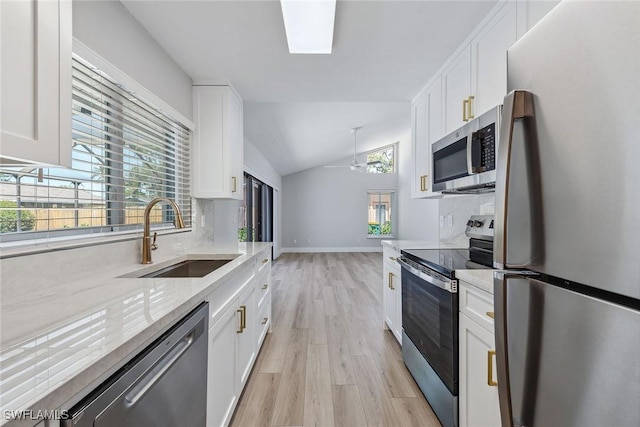 1196 Westlake Blvd, Naples, FL 34103 - kitchen with appliances with stainless steel finishes, a sink, white cabinets, lofted ceiling, and light wood-style floors