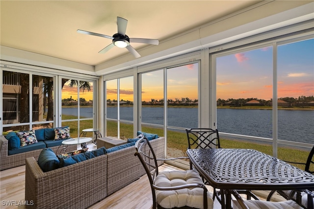 sunroom featuring a healthy amount of sunlight, a water view, ceiling fan, and an outdoor hangout area