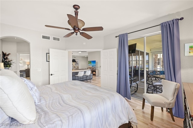 bedroom with visible vents, a ceiling fan, access to exterior, light wood-style floors, and arched walkways